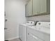 Laundry room with washer, dryer, and green cabinets at 9114 Forge Breeze Loop, Wesley Chapel, FL 33545