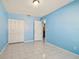 Bedroom with light blue walls, tiled floors, and a double door closet at 10323 Del Mar Cir, Tampa, FL 33624