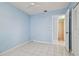 Clean bedroom with light blue walls, tiled floors, and bathroom access at 10323 Del Mar Cir, Tampa, FL 33624