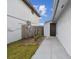 Side entrance to the house with a wooden fence and concrete pathway at 10323 Del Mar Cir, Tampa, FL 33624