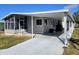 Gray manufactured home with carport and screened porch at 12501 Ulmerton Rd # 188, Largo, FL 33774