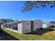 Grey mobile home with covered patio and AC unit at 12501 Ulmerton Rd # 188, Largo, FL 33774