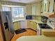 Galley kitchen with wood cabinets, stainless steel appliances, and laminate flooring at 12501 Ulmerton Rd # 188, Largo, FL 33774