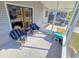 Screened porch with two wicker chairs and small table at 12501 Ulmerton Rd # 188, Largo, FL 33774