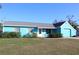 Light teal single story home with gray roof, white trim, and attached garage at 1322 Kenmore St, Port Charlotte, FL 33952