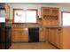 Kitchen featuring wood cabinets, black appliances, a window, and tile floors for a warm, inviting atmosphere at 1322 Kenmore St, Port Charlotte, FL 33952