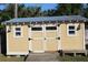 Backyard outbuilding with double doors, windows, and a small porch at 1322 Kenmore St, Port Charlotte, FL 33952
