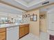 Kitchen with wood cabinets, white appliances, and tile floors at 134 Mariner Dr # 134, Tarpon Springs, FL 34689