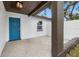 Front entry with teal door, covered porch and gravel at 1399 Grapeleaf Ct, Tarpon Springs, FL 34689