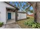 House exterior featuring a teal front door and landscaping at 1399 Grapeleaf Ct, Tarpon Springs, FL 34689