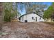 Side view of a freshly painted house with a large backyard and mature trees at 1399 Grapeleaf Ct, Tarpon Springs, FL 34689