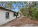 Rear view of a single story house with a large backyard and mature trees at 1399 Grapeleaf Ct, Tarpon Springs, FL 34689