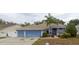 House exterior featuring a two-car garage and palm tree at 1530 Davenport Dr, New Port Richey, FL 34655