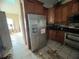 Kitchen with stainless steel refrigerator and wooden cabinets at 1530 Davenport Dr, New Port Richey, FL 34655