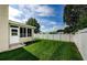 Large backyard with a grassy area and white fence at 1553 Regal Mist Loop, Trinity, FL 34655