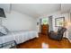 Cozy bedroom with hardwood floors, dresser, and comfortable seating at 1553 Regal Mist Loop, Trinity, FL 34655