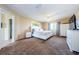 Large main bedroom with plush carpet, ceiling fan, and ensuite bathroom at 1553 Regal Mist Loop, Trinity, FL 34655