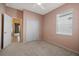 Carpeted bedroom offering a double closet, a sunny window, and access to another room via a white paneled door at 15555 Martinmeadow Dr, Lithia, FL 33547