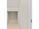 Hallway with neutral paint colors, tile flooring, and entry to an under-stairs storage space at 15555 Martinmeadow Dr, Lithia, FL 33547