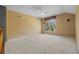 Spacious open living area with vaulted ceilings, neutral carpet, large window, and ceiling fan for a bright and airy feel at 15555 Martinmeadow Dr, Lithia, FL 33547