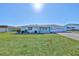 Ranch style home with a white garage door and green lawn at 1806 Burlington Cir, Sun City Center, FL 33573