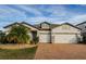 Two-story house with a three-car garage and brick paver driveway at 19263 Briarbrook Dr, Tampa, FL 33647