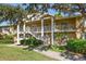 Two-story condo building with lush landscaping and a walkway at 2112 Gulf View Blvd, Dunedin, FL 34698