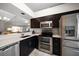 Modern kitchen boasts stainless steel appliances and dark cabinetry at 2112 Gulf View Blvd, Dunedin, FL 34698