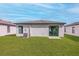 Newly built home with grassy backyard and sliding glass door at 29603 Fedora Cir, Brooksville, FL 34602