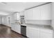 White shaker cabinets, granite countertops, and stainless steel dishwasher at 29603 Fedora Cir, Brooksville, FL 34602