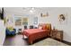 Charming bedroom with hardwood floors, a bed with an orange bedspread, and natural light from the window at 403 Weeburn Rd, Temple Terrace, FL 33617