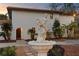 Two-story stucco home with terra cotta roof, arched front door, mature trees, and decorative water fountain at 403 Weeburn Rd, Temple Terrace, FL 33617