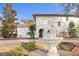 Two-story stucco home with tile roof featuring mature landscaping, decorative fountain, and arched front door at 403 Weeburn Rd, Temple Terrace, FL 33617