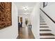 Hallway with decorative tile flooring, arched doorways and access to stairs with wood trim at 403 Weeburn Rd, Temple Terrace, FL 33617