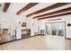 Spacious living area featuring tiled floors, wood-beamed ceilings, arched doorways, and sliders to the patio at 403 Weeburn Rd, Temple Terrace, FL 33617