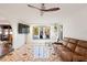 Spacious living room features decorative tiled floors, a comfortable leather sofa and views of outdoor patio at 403 Weeburn Rd, Temple Terrace, FL 33617