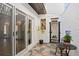 Cozy outdoor patio with tile flooring, patio furniture, potted plant, iron gate, and a view of the interior at 403 Weeburn Rd, Temple Terrace, FL 33617