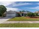 House exterior showcasing a well-maintained lawn, landscaping, and a two-car garage at 4726 Windflower Cir, Tampa, FL 33624