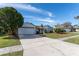 Exterior view of a single-story house with a spacious driveway and lush landscaping at 4726 Windflower Cir, Tampa, FL 33624