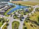 Aerial view of a community entrance featuring lush landscaping, serene water features, and well-maintained roadways at 4748 Ballast Crest Cv, Land O Lakes, FL 34638