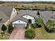 Aerial view of a well-maintained home showcasing lush landscaping, a brick driveway, and a neutral color scheme at 4748 Ballast Crest Cv, Land O Lakes, FL 34638