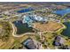 Wide aerial view showcases the resort-style community with a pool, clubhouse, and winding waterways at 4748 Ballast Crest Cv, Land O Lakes, FL 34638