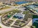 Aerial view of community garden with plots, center gazebo with tables, landscaping, and adjacent parking area and tennis courts at 4748 Ballast Crest Cv, Land O Lakes, FL 34638