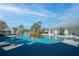 A beautifully designed community pool area with ample seating, shade, palm trees, and a central island at 4748 Ballast Crest Cv, Land O Lakes, FL 34638