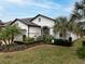 Charming one-story home featuring a well-manicured lawn, lush landscaping, and elegant architectural details at 4748 Ballast Crest Cv, Land O Lakes, FL 34638