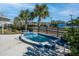 Outdoor hot tub with blue tile trim surrounded by lush landscaping and metal safety railings near the community pool at 4748 Ballast Crest Cv, Land O Lakes, FL 34638