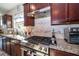 Kitchen featuring stainless steel oven and range with decorative tile backsplash and granite counters at 4748 Ballast Crest Cv, Land O Lakes, FL 34638