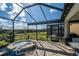 Covered patio with an outdoor kitchen, screened-in pool and landscaped backyard at 4748 Ballast Crest Cv, Land O Lakes, FL 34638