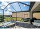 Screened-in patio features an outdoor kitchen and a view of the landscaped backyard at 4748 Ballast Crest Cv, Land O Lakes, FL 34638