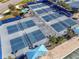 Aerial view of multiple outdoor pickleball courts with blue surfacing and net systems in a recreational community space at 4748 Ballast Crest Cv, Land O Lakes, FL 34638